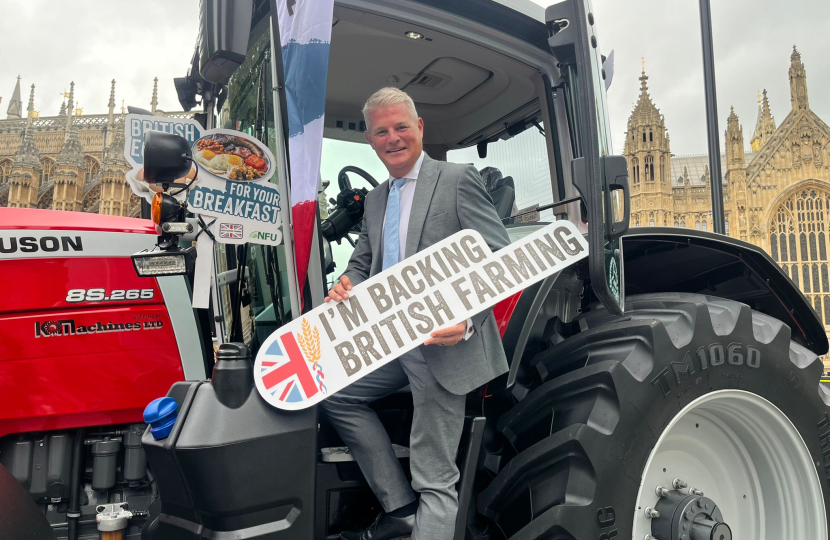 Stuart Andrew MP on a tractor holding "I'm backing British Farming" 