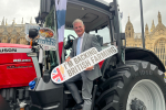 Stuart Andrew MP on a tractor holding "I'm backing British Farming" 